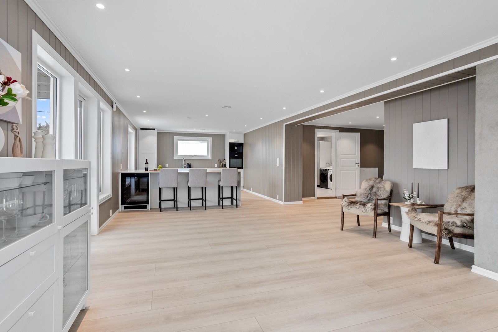 Stort allrom med stue og kjøkken i sosial løsning, adskilt i ulike soner. Galleribilde