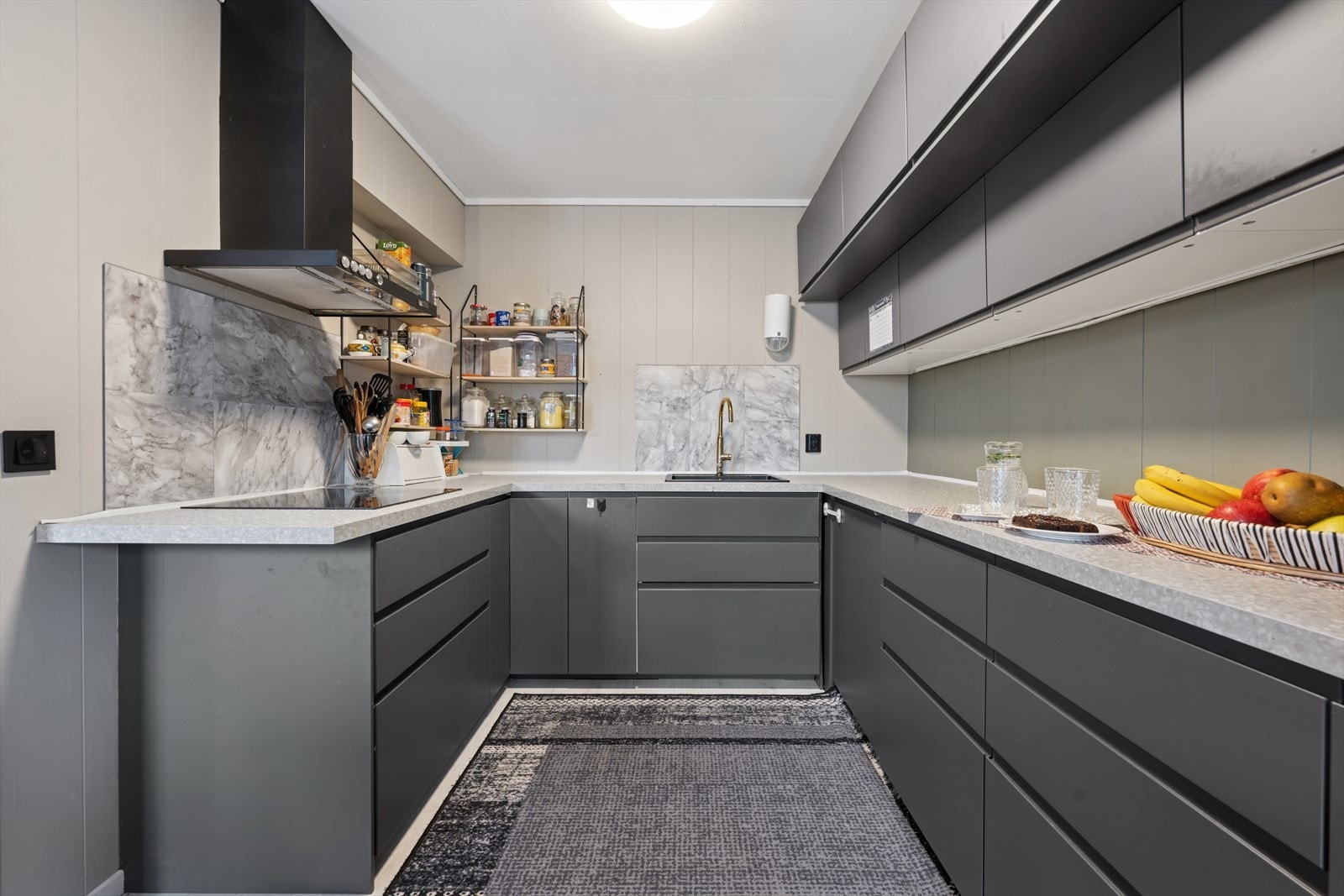 Det er montert en nyere og stilren kjøkkeninnredning med mørke glatte fronter. Galleribilde