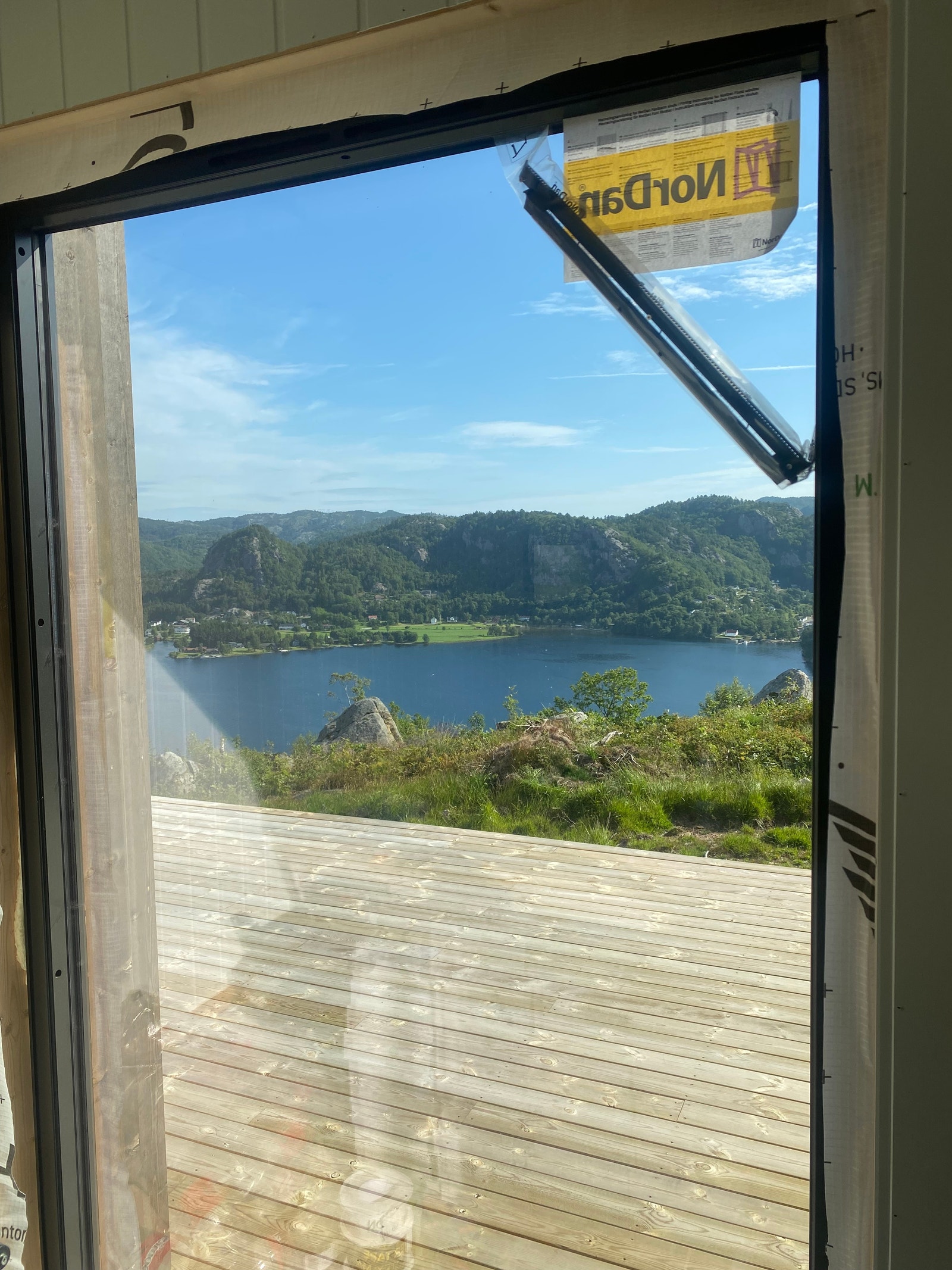 Når en stiger i hoveddøra har en gjennomsyn gjennom hytta og rett ut til fjorden. Dette er utsikten fra spisebordet. Galleribilde