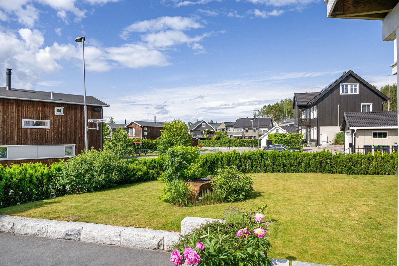 Deler av tomten er hyggelig opparbeidet med plen og forskjellig beplantning Galleribilde