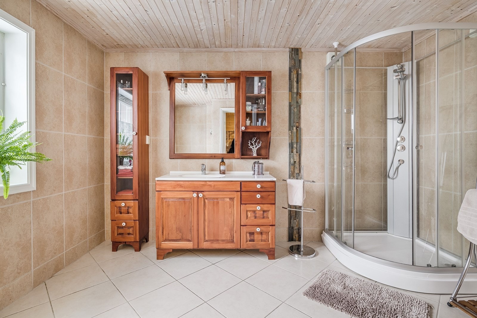 Baderomsinnredning med god oppbevaringsplass og nedfelt servant, speil med belysning over. Galleribilde