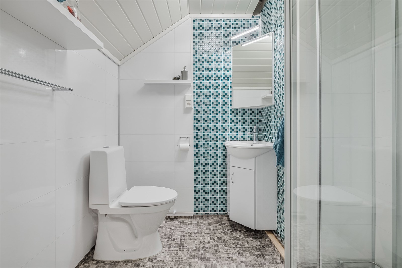 I tilknytning til soverommene i 2. etasje har du et lyst baderom som ble pusset opp i 2018. Baderommet har belegg på gulv og lyse våtromsplater på veggene kombinert med mosaikkfliser. Galleribilde