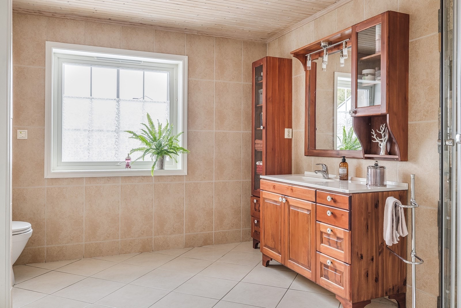 Stort og lyst baderom i 1. etasje som ble pusset opp i 2003. Takstmann opplyser om behov for renovering av badet. Galleribilde