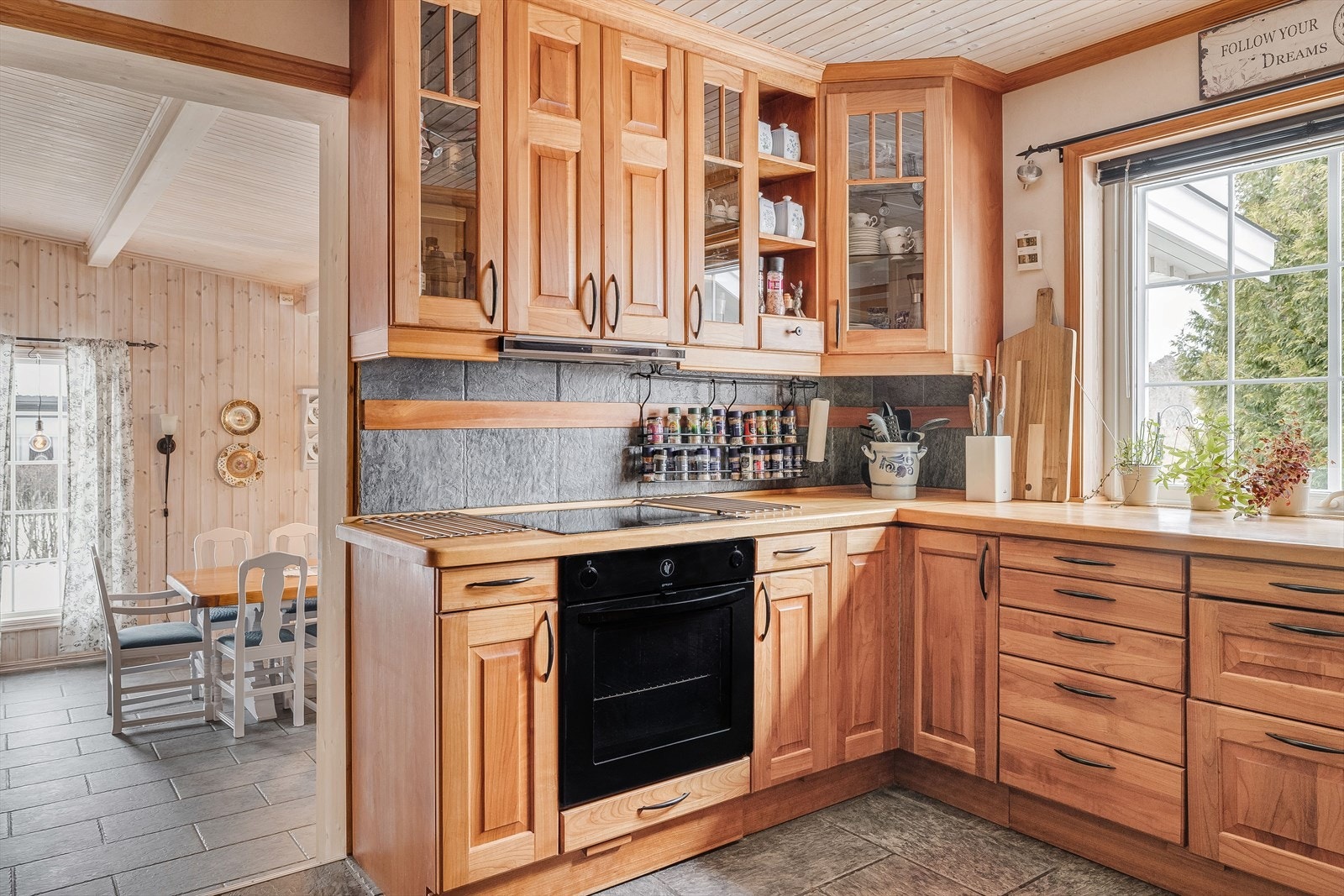 Kjøkken er fint plassert mellom spisestuen og gangen. Også på kjøkkenet er det flislagt gulv med gulvvarme. Galleribilde