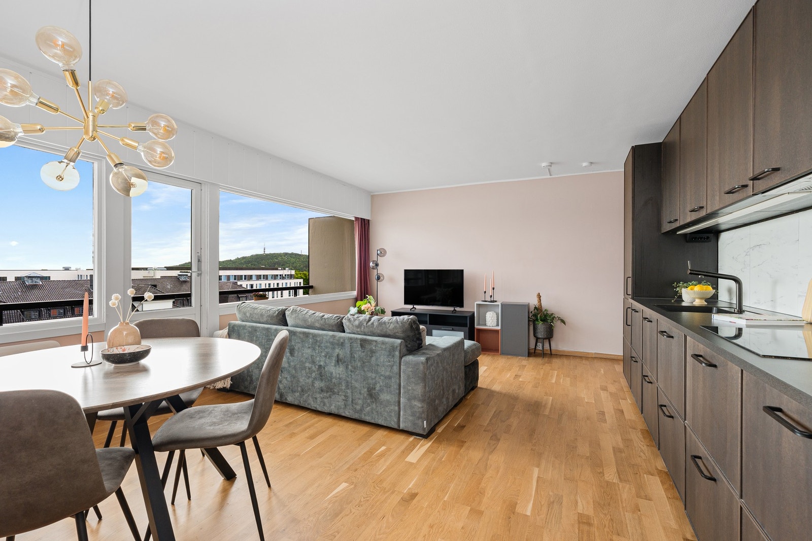 Videre kommer vi inn til stuen og kjøkkenet som har en åpen løsning. Store vindusflater slipper inn godt med lys. Galleribilde