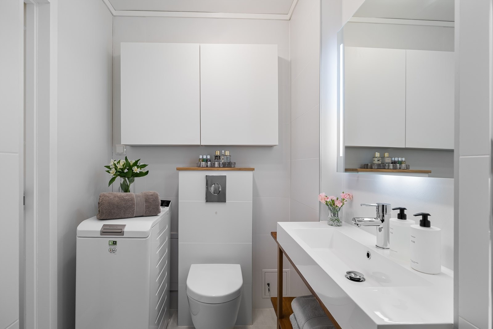 Delikat flislagt bad med gulvvarme - Utstyrt med innfellbare dusjdører, opplegg for vaskemaskin, servant, veggmontert wc og stoppekran. Galleribilde