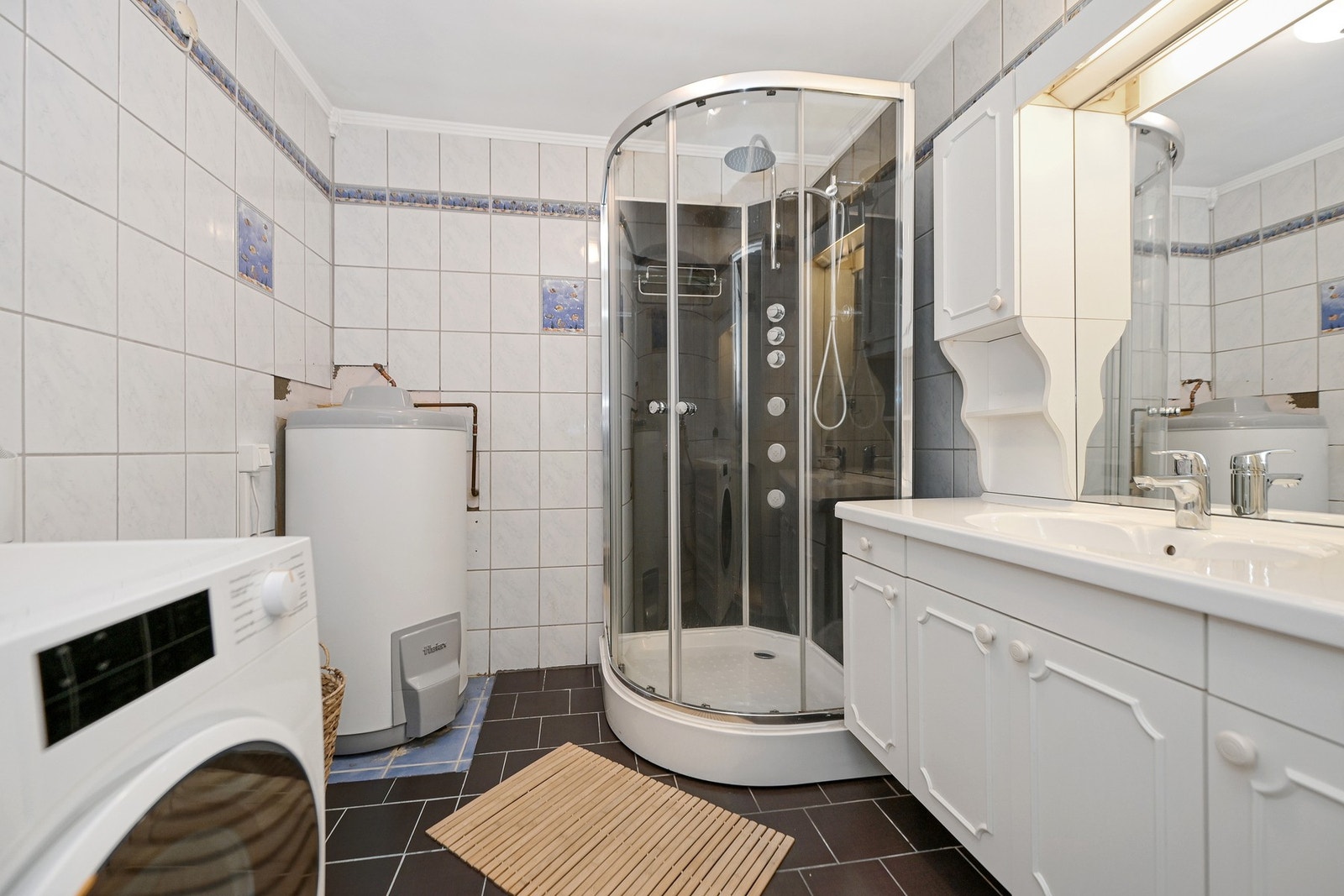 Boligen har praktisk bad i 2. etasje, smart plassert mellom soverommene. Badet er innredet med nedfelt servant, dusjkabinett og opplegg for vaskemaskin. Galleribilde