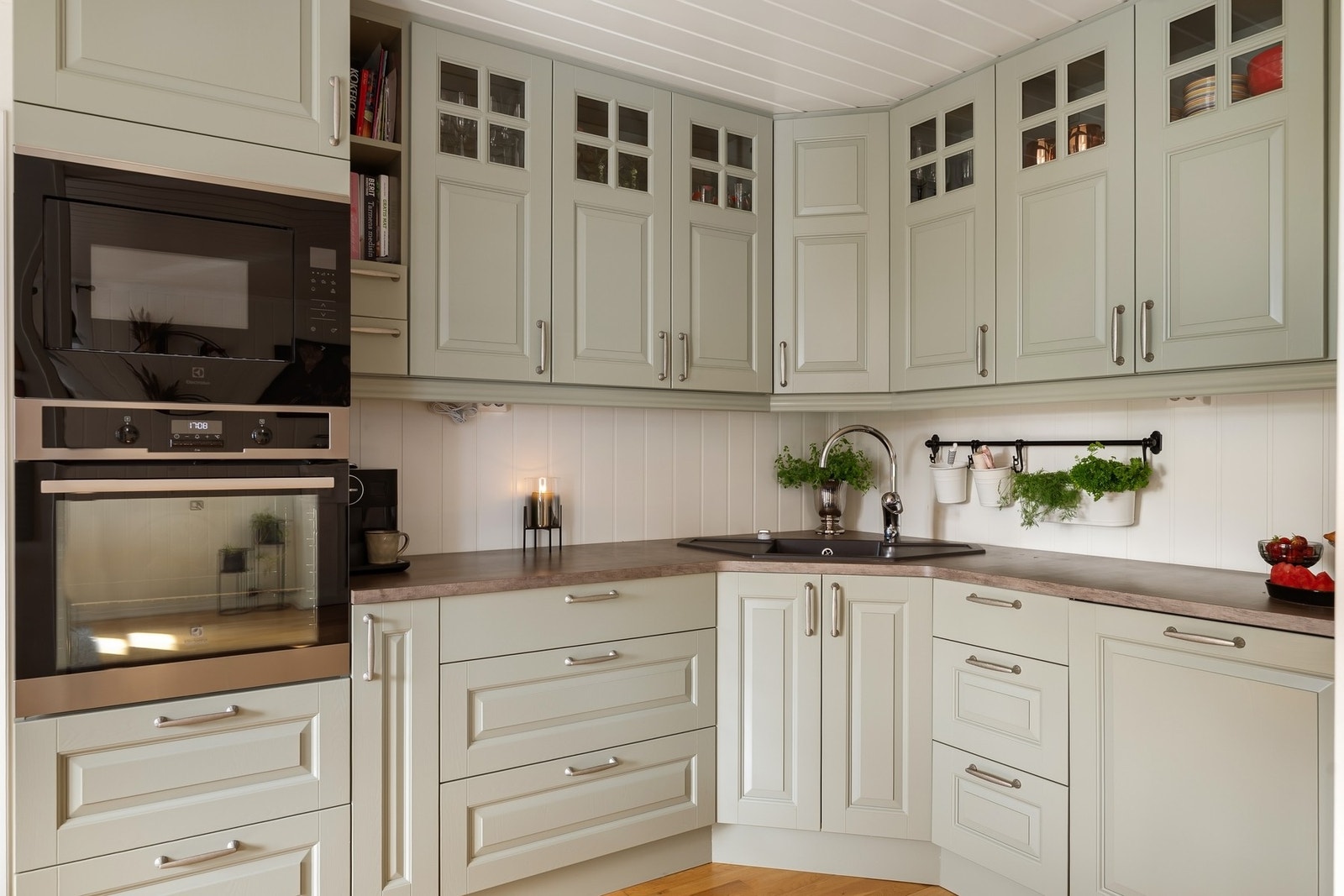 Pent kjøkken med profilerte fronter og integrerte hvitevarer. Galleribilde