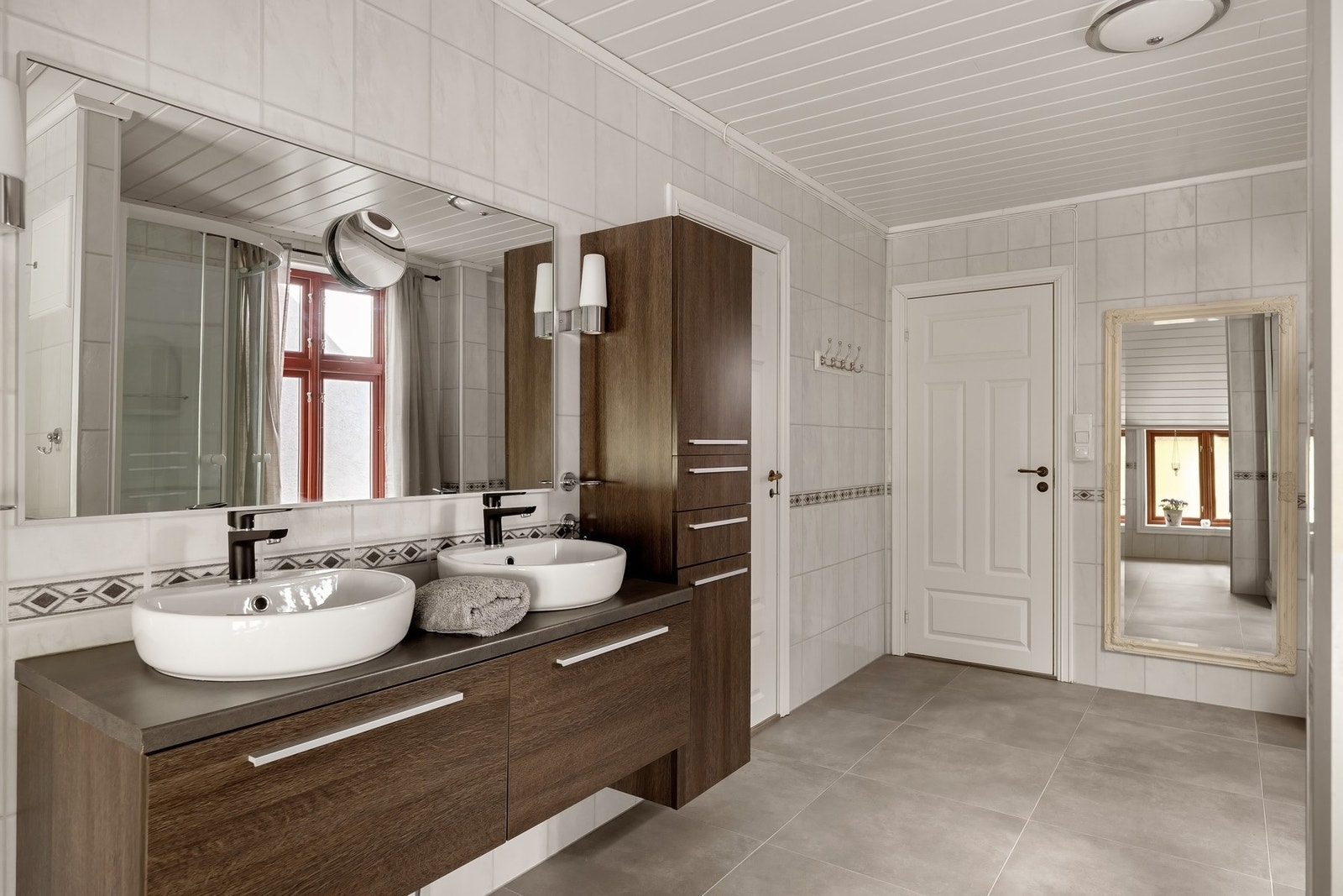 Romslig bad med to servanter, dusjkabinett, toalett, badekar og opplegg for vaskemaskin. Galleribilde