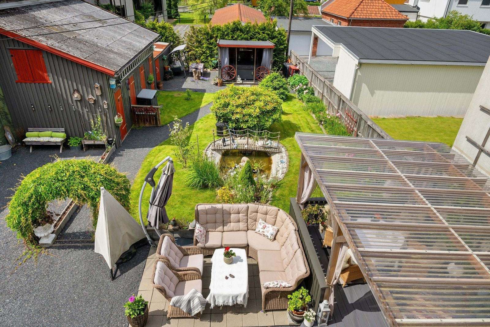 Pent opparbeidet tomt med flere sittegrupper, jacuzzi, boder og hagedam. Galleribilde