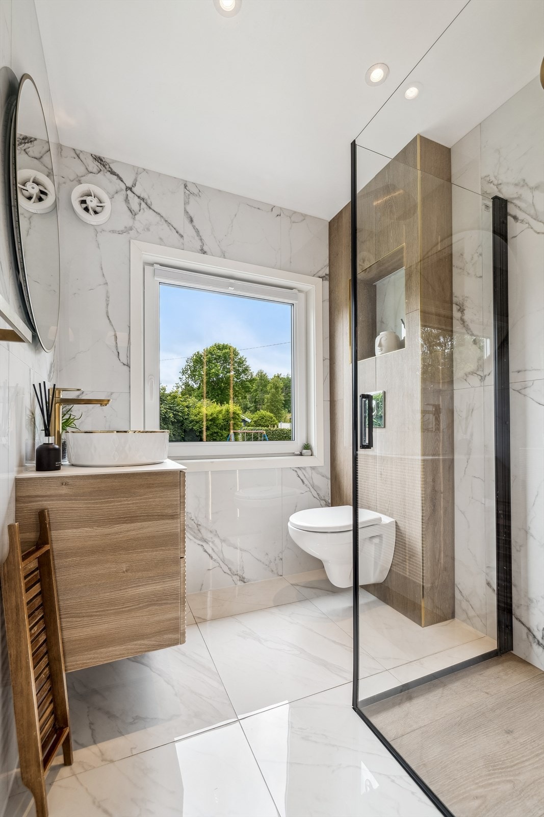 Lekkert flislagt bad fra 2024 med dusjnisje, vegghengt wc og stilig vask med pen innredning. Galleribilde