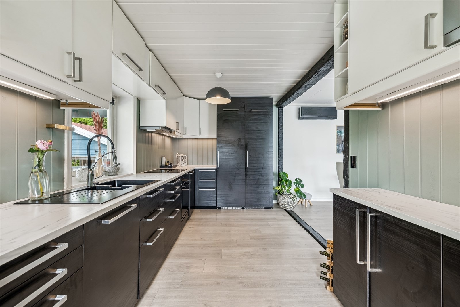 Stort og romslig kjøkken med innredning med slette dører og laminat benkeplate. Galleribilde