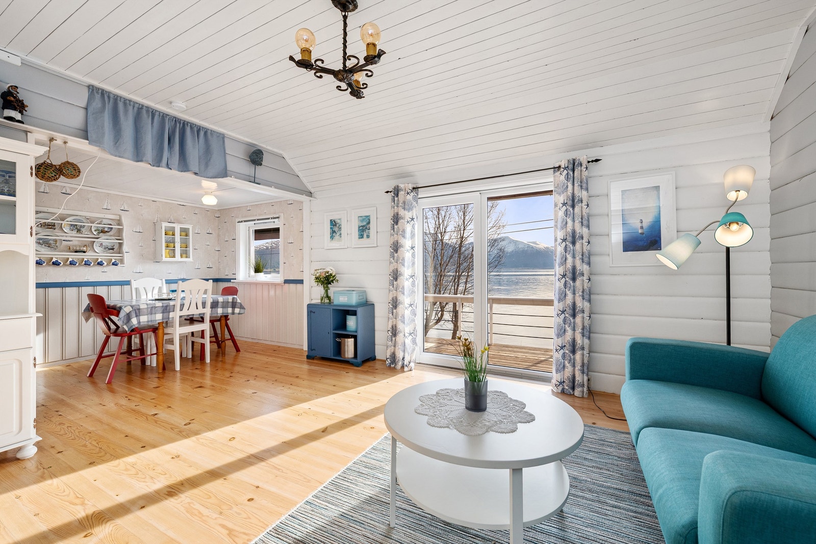 Stue og kjøkken i åpen løsning med nyere skyvedør ut til sydvendt terrasse Galleribilde