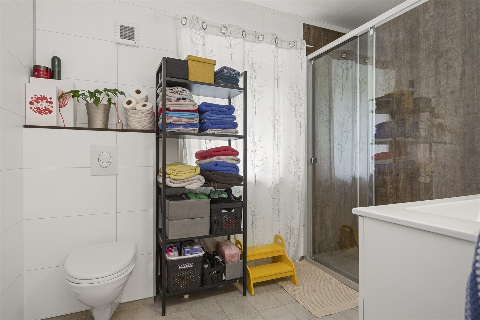 Delikat flislagt bad i 1. etg. med dusjhjørne og vegghengt toalett Galleribilde