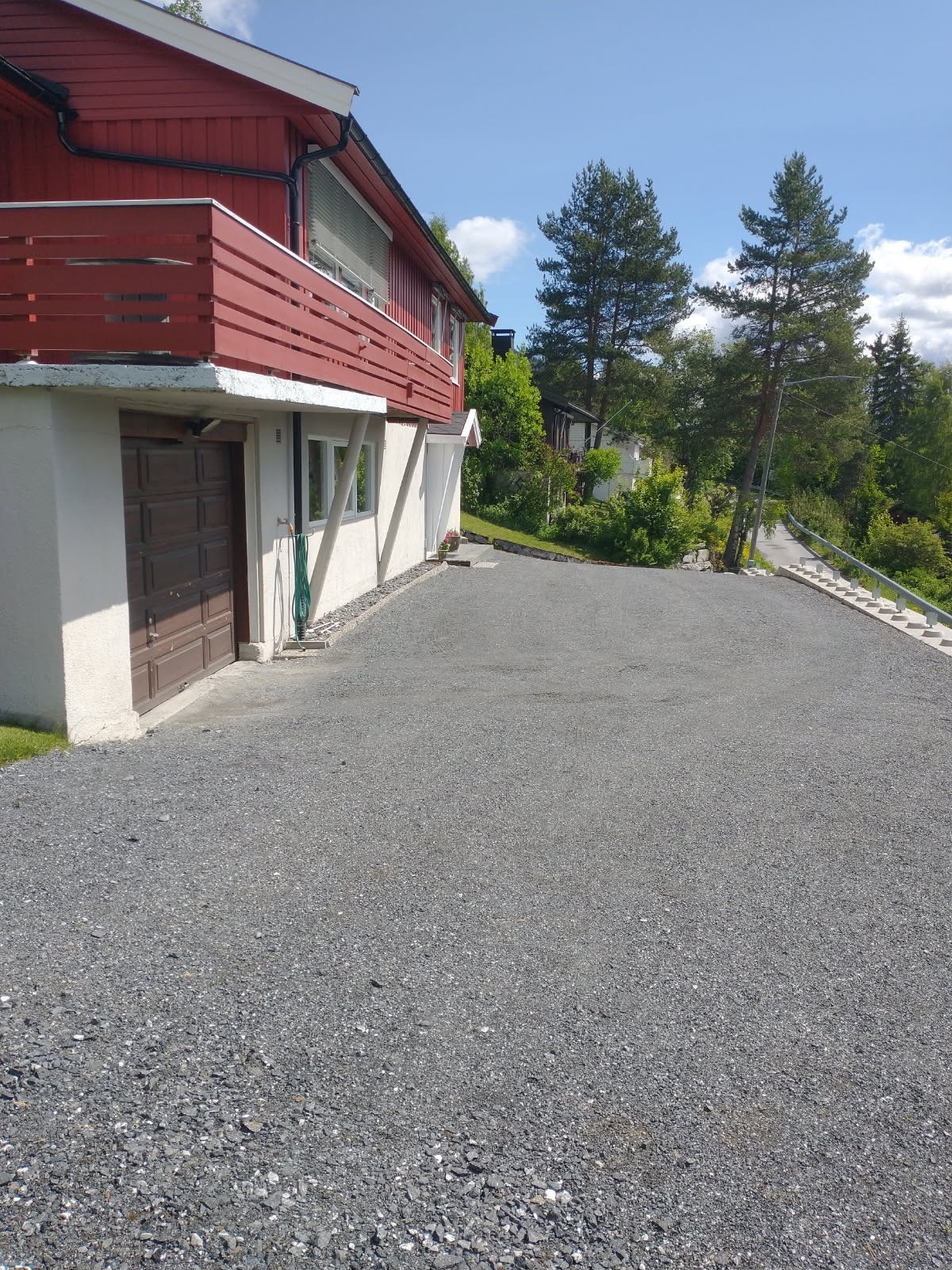 Gruset innkjørsel og parkering i garasje eller på eiendommen ellers. Galleribilde