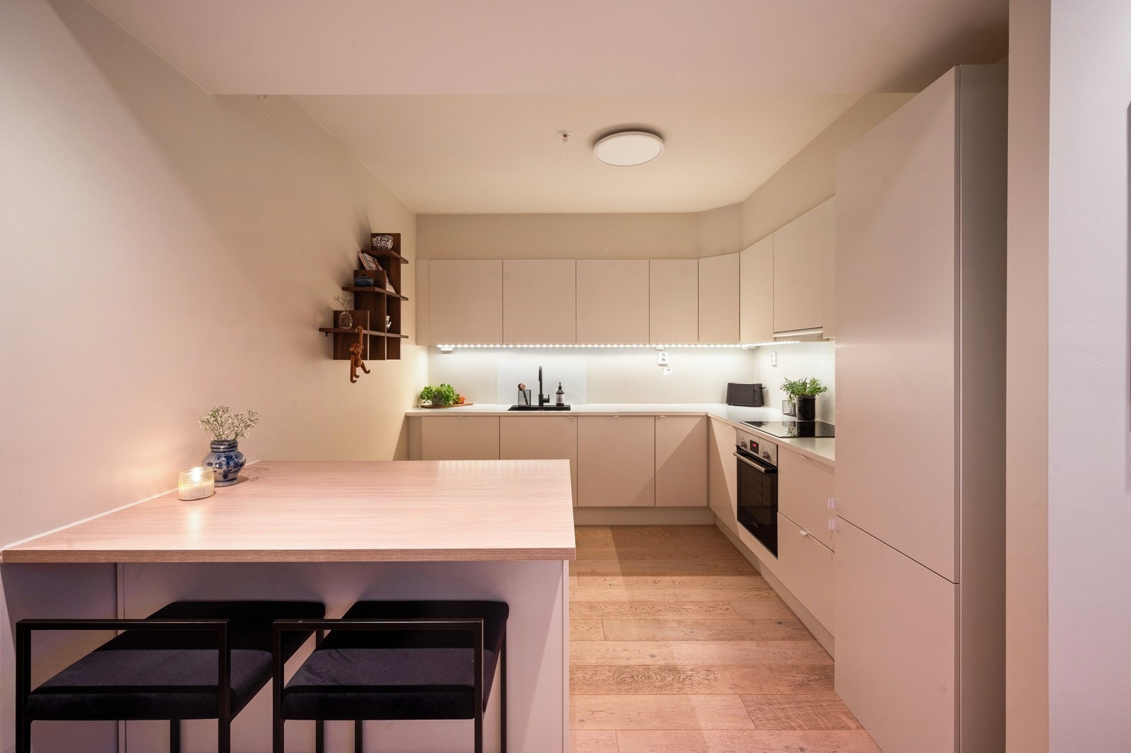 Leiligheten har et stilrent og funksjonelt kjøkken med glatte skapfronter og laminat benkeplater. Galleribilde