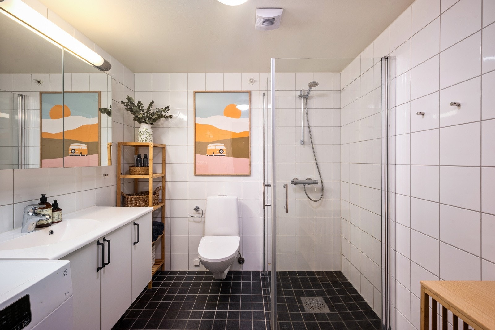 Baderommet er utstyrt med en romslig servant med skapinnredning, vegghengt toalett og en dusjløsning med dusjdører i herdet glass. Galleribilde