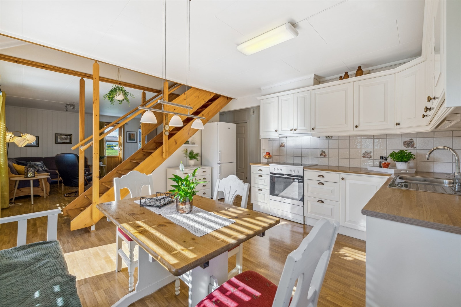 Kjøkkenet er lyst med innredning i hjørneløsning fra 2008. Innredningen består av overskap, underskap og skuffer med profilerte fronter, laminerte benkeplater og enkelte glassdører på overskap. Galleribilde