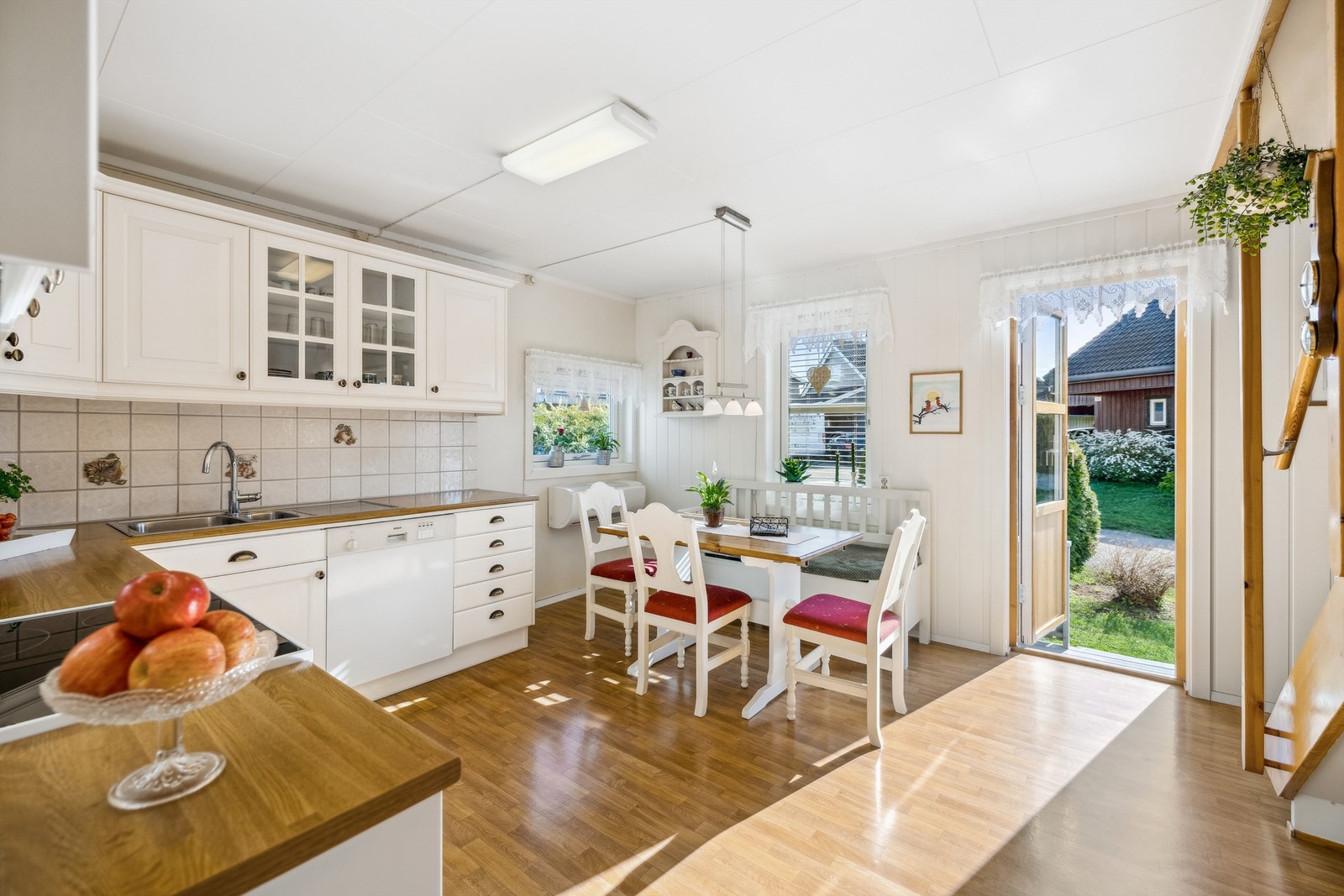 Kjøkkenet er romslig med god plass til å innredet med kjøkkenbord ved vinduene, og terrassedøren slipper deg ut til en liten terrasseplatting. Det er montert varmepumpe under det ene vinduet på kjøkkenet. Galleribilde