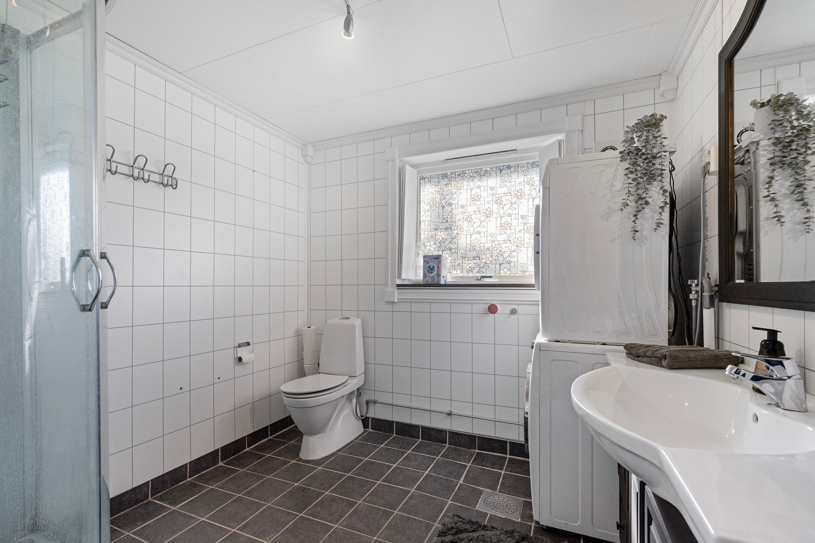 Et moderne og delikat bad med flislagte gulv, baderomsplater på veggene og komfortabel gulvvarme Galleribilde