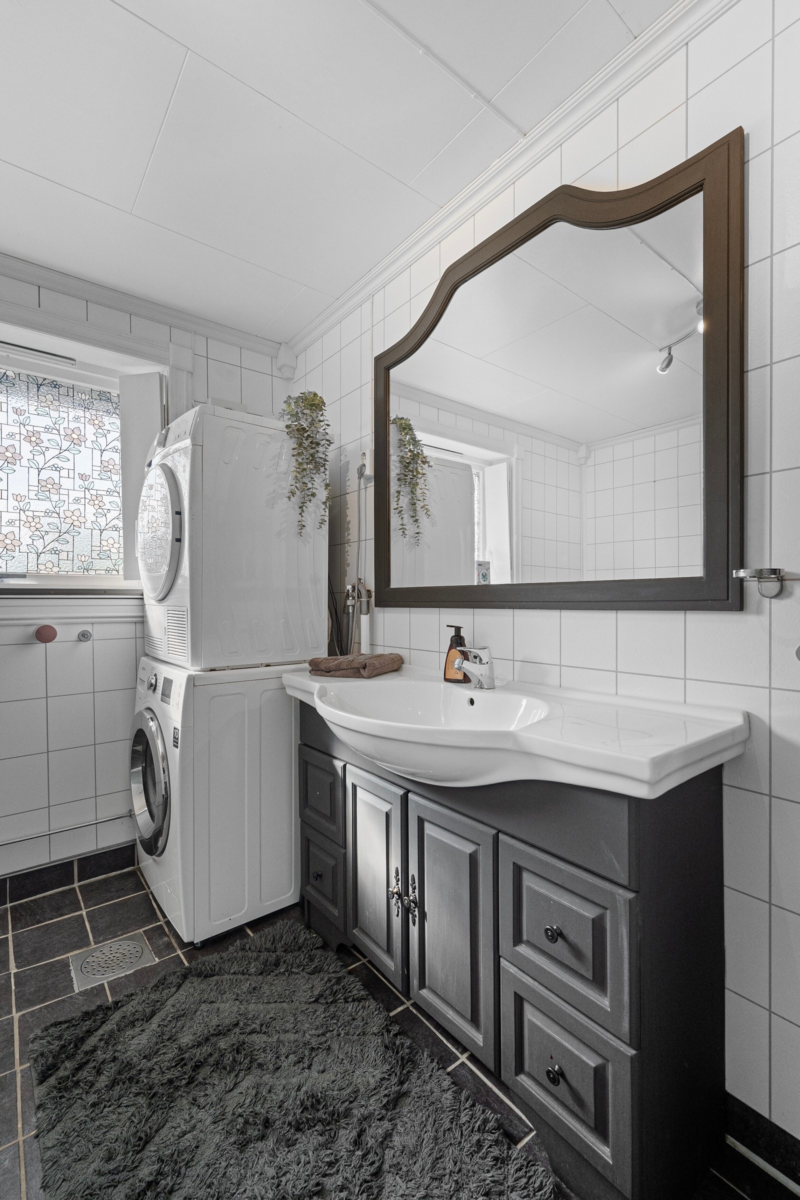 Innredningen inkluderer servant med underskap, dusjkabinett og opplegg for vaskemaskin Galleribilde