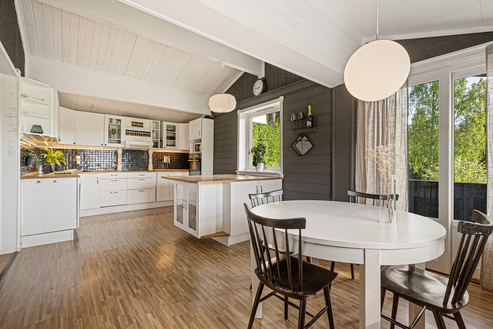 Kjøkkenet er utstyrt med Marbodal-innredning med hvite profilerte fronter, heltre benkeplate og fliser over benk Galleribilde