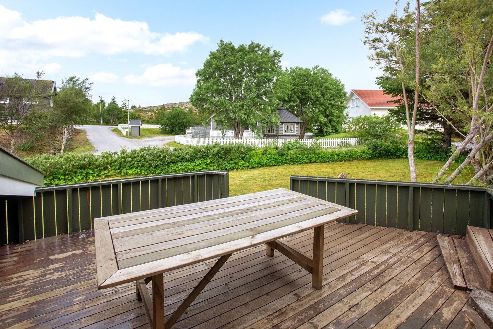 Terrasseområde i bakkant av garasje og mot plen Galleribilde