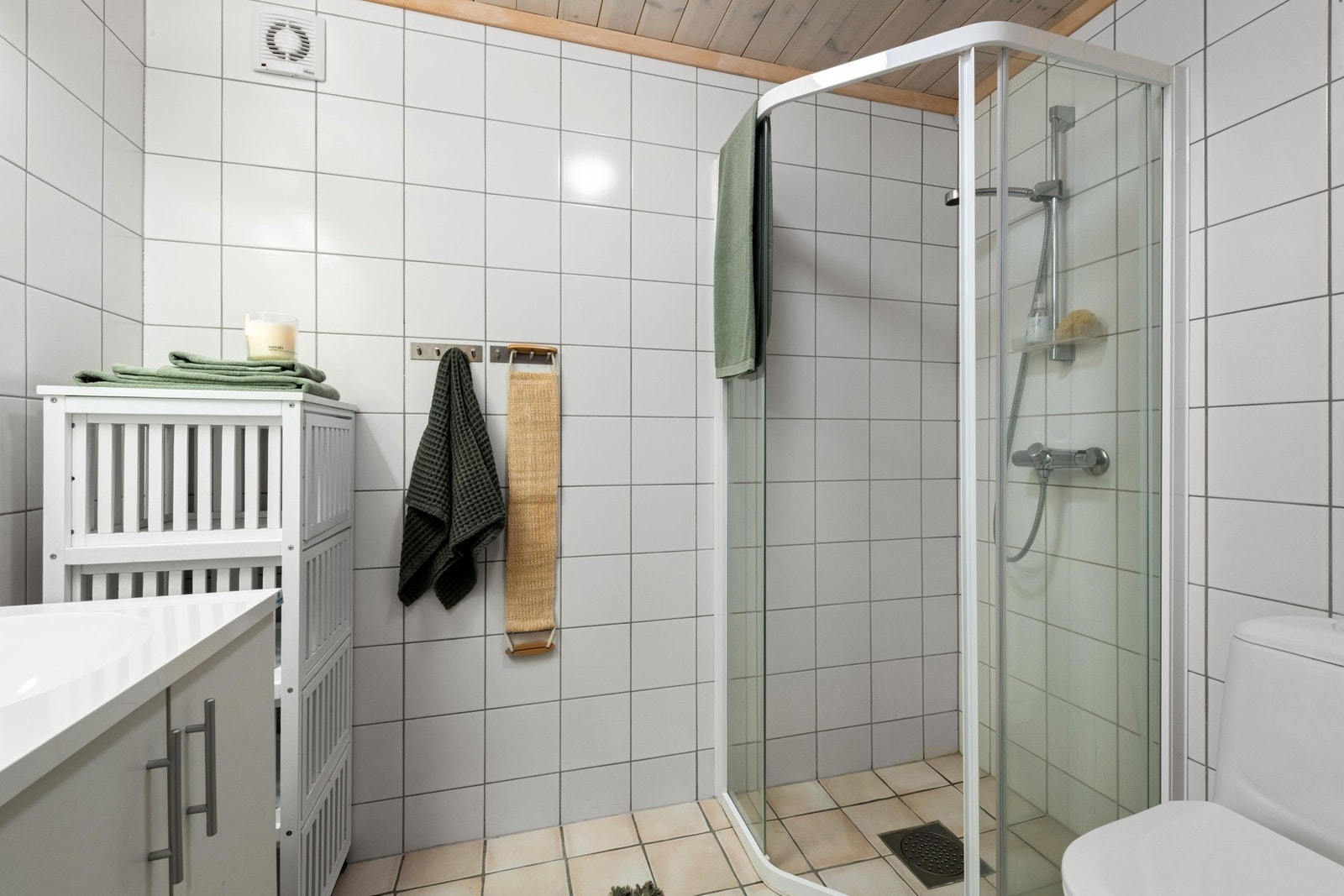 Badet er innredet med toalett, hjørnedusj og servant med innredning. Galleribilde