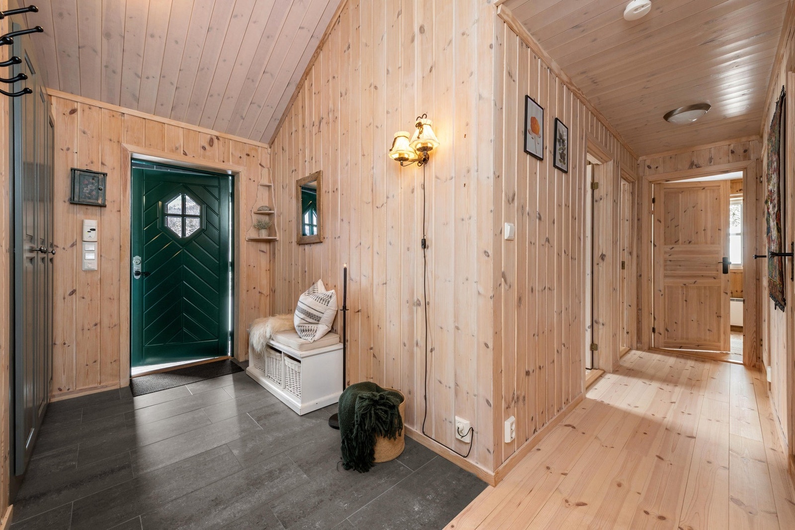 Når du kommer inn i hytten blir du møtt med flislagt gulv og plassbygd garderobeløsning. Galleribilde