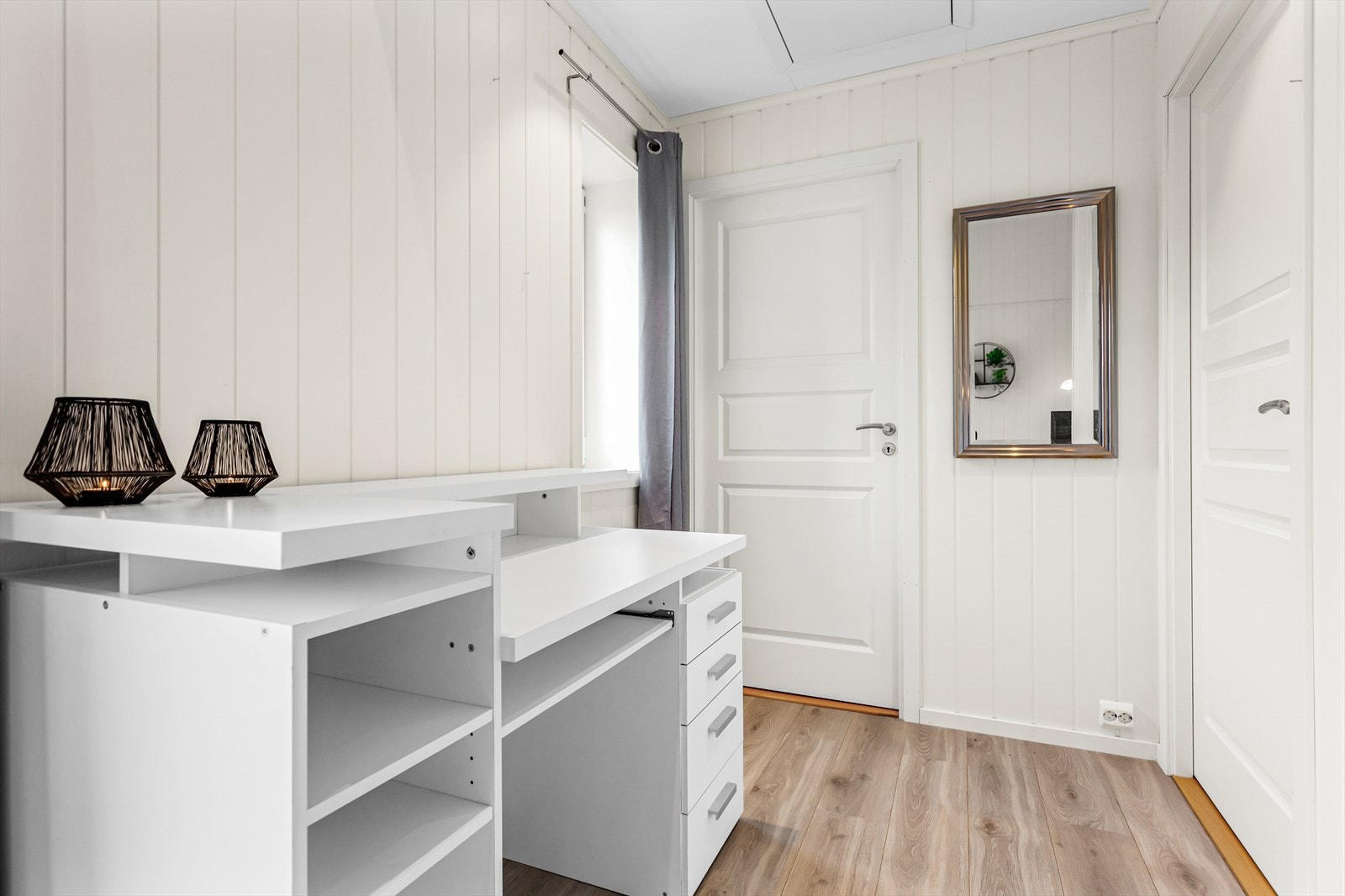 Eier har laget seg en kontorplass ved inngangen til soverom og bad for å utnytte plassen i leiligheten godt Galleribilde