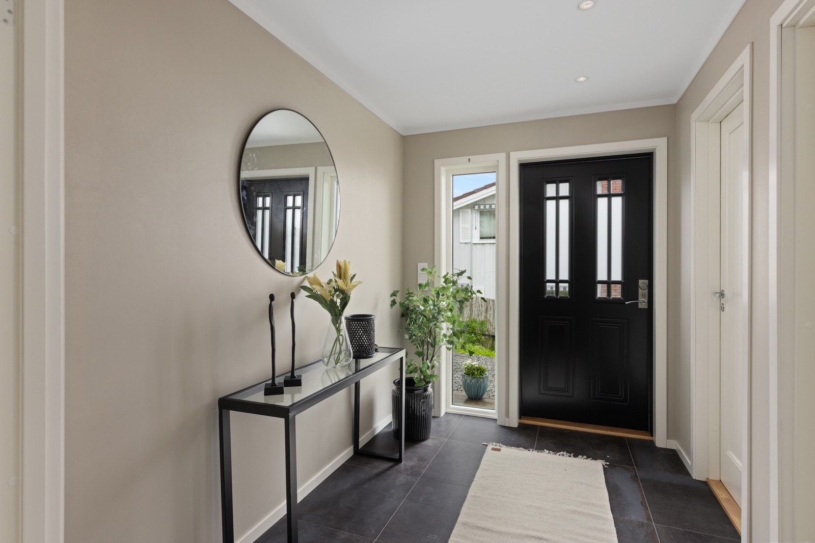 Den innbydende entré med downlights i himlingen og elegante, mørke fliser på gulvet med varme, noe som gir en luksuriøs følelse. Galleribilde