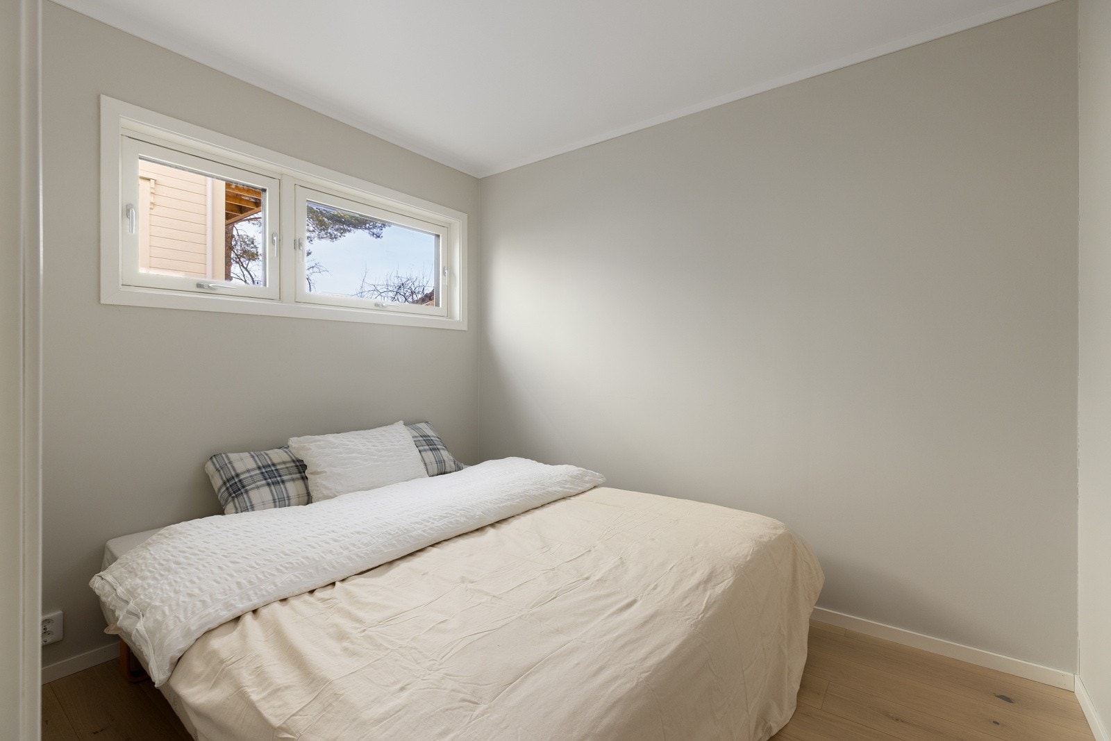 Soverom med enstavs parkett, gulvvarme og moderne malte overflater. Galleribilde