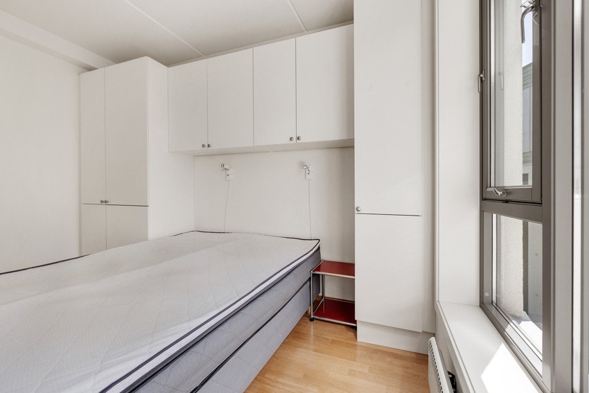 Romslig soverom med garderobeskap og seng Galleribilde