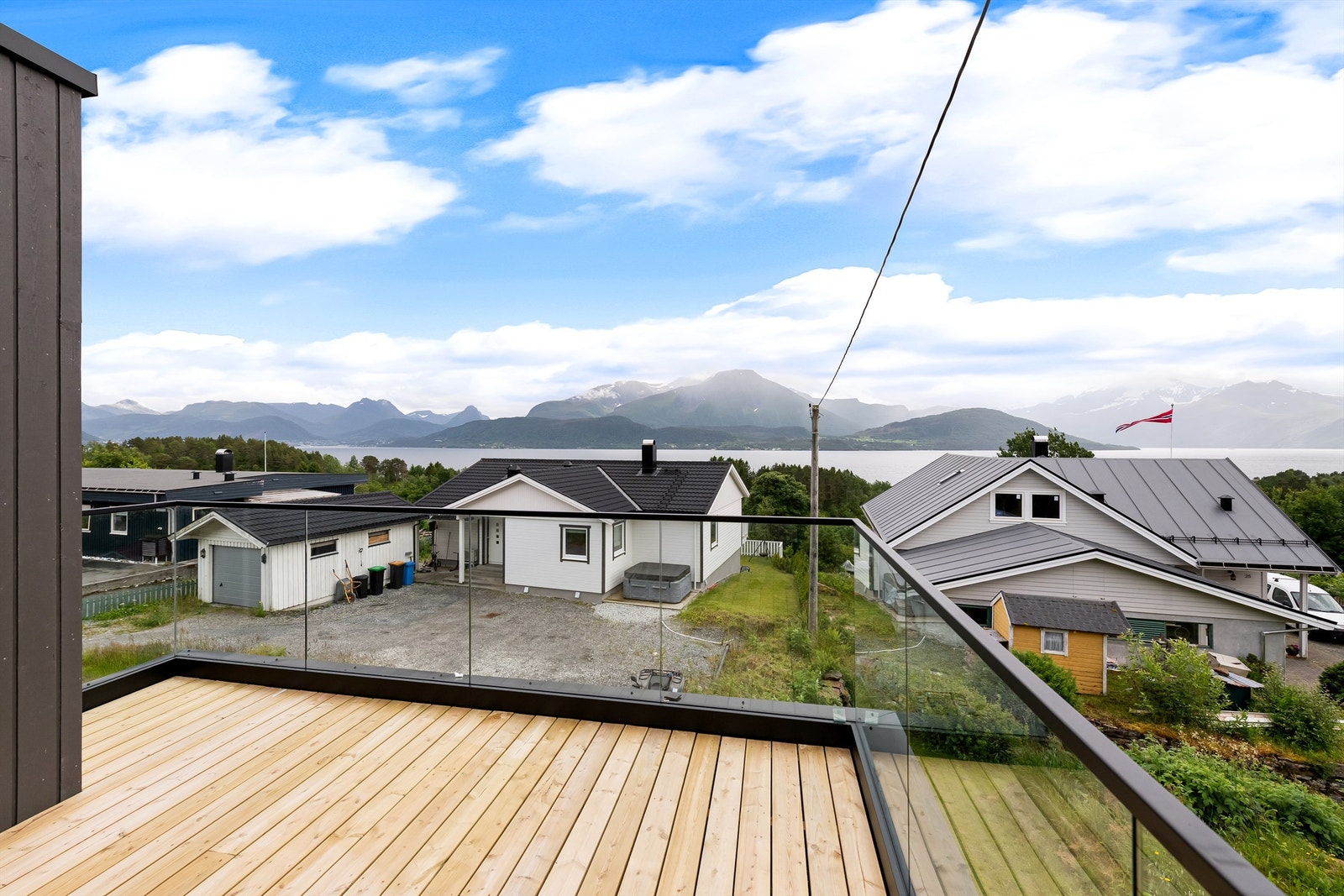 Balkong i 1. etasje ut glassrekkverk og flott utsikt mot fjord og fjell Galleribilde