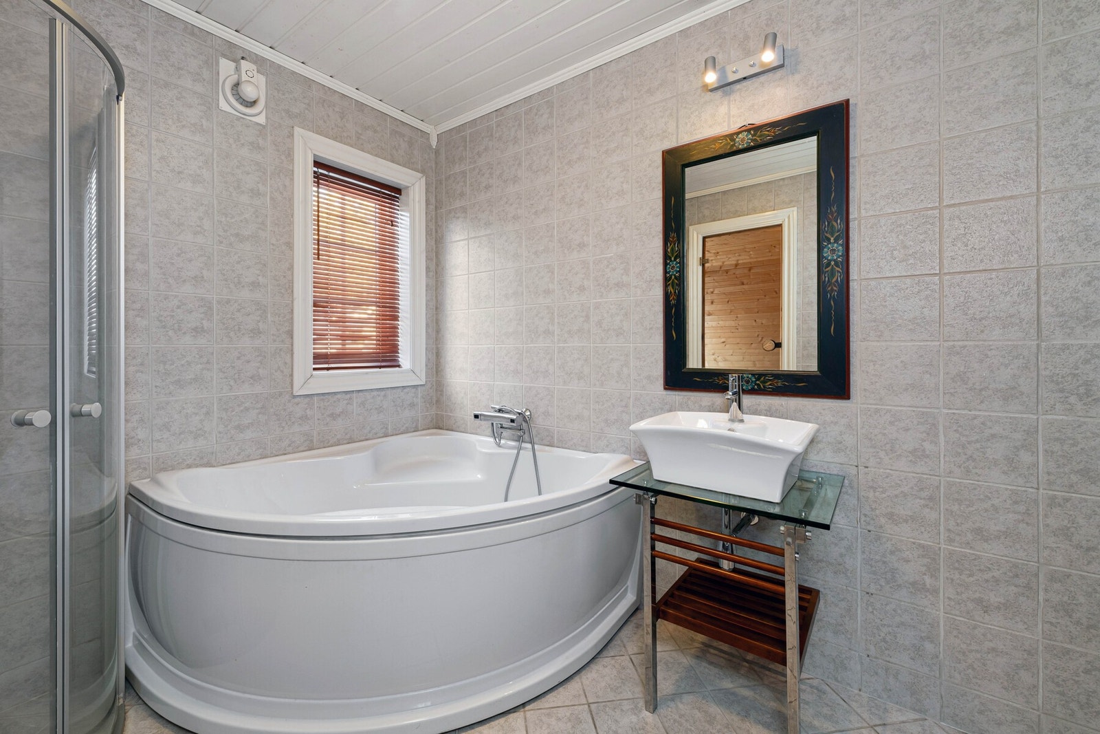 Badet er innredet med badekar, dusj, vask, toalett, badstue og opplegg for vaskemaskin. Galleribilde