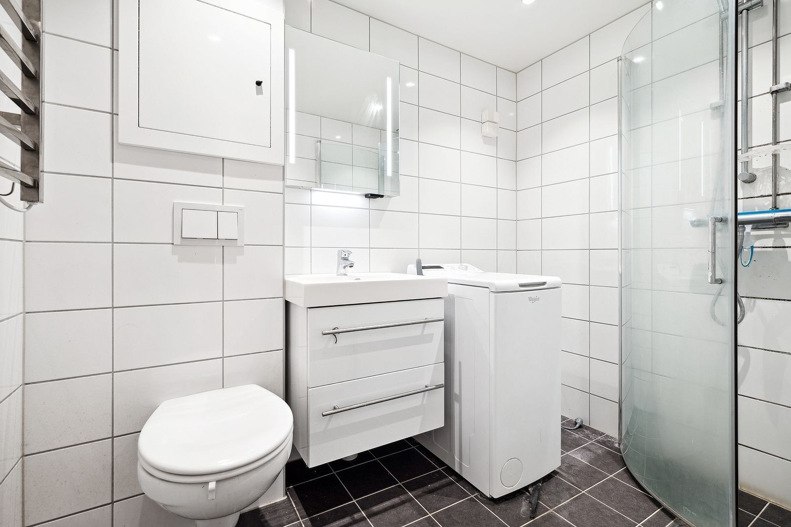 Flislagta bad med downlights i tak og vaskemaskin. Galleribilde