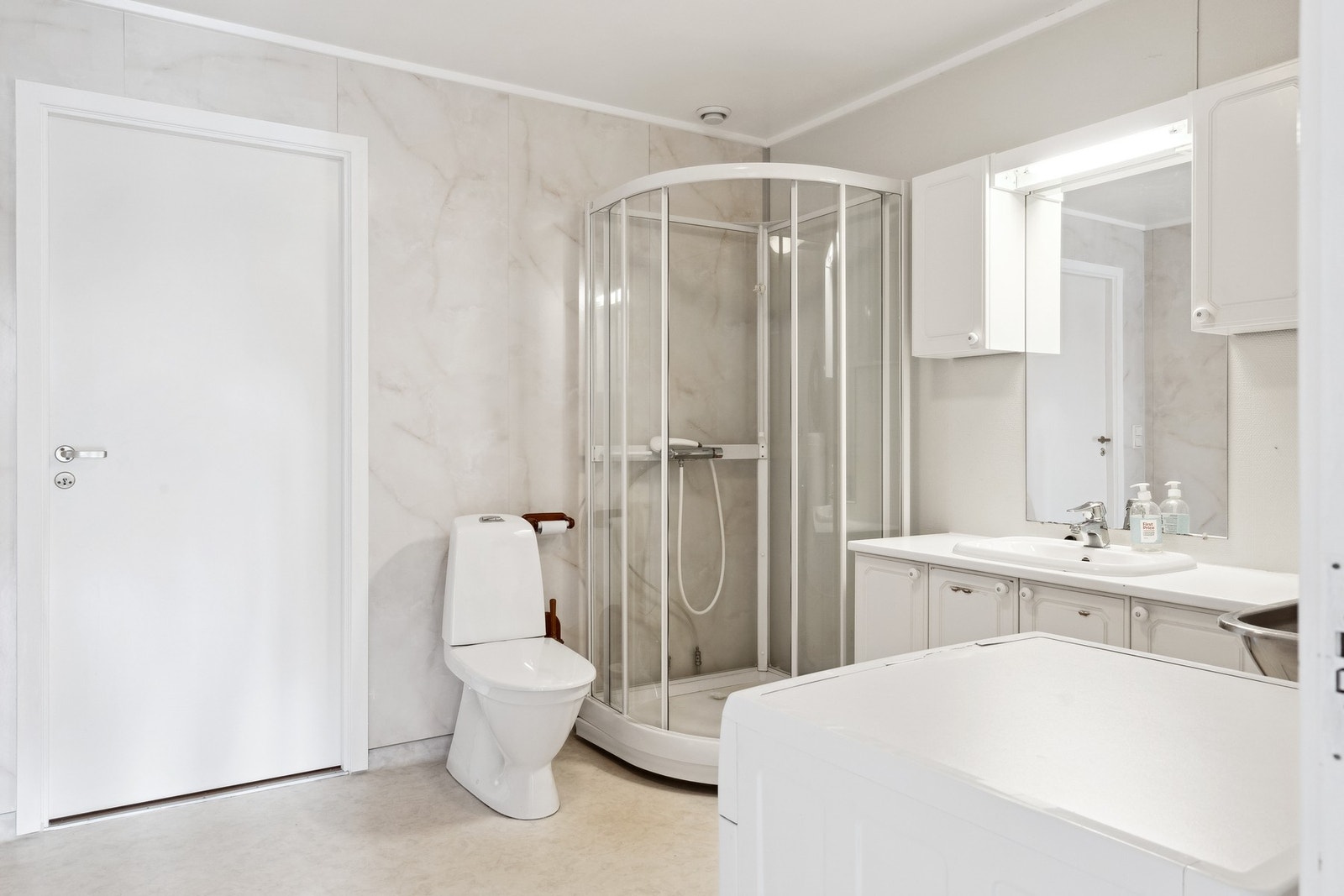 Romslig bad/vaskerom med gjennomgang fra entré og gang mot soverom Galleribilde