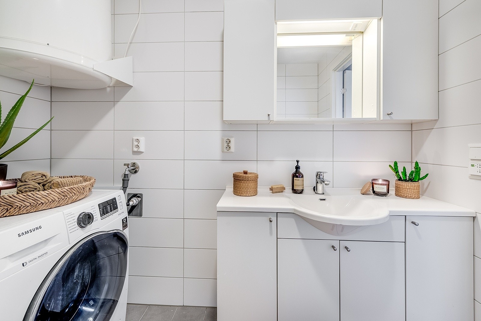 Badet er utstyrt med dusjkabinett, opplegg for vaskemaskin, varmtvannsbereder, wc og baderomsinnredning Galleribilde