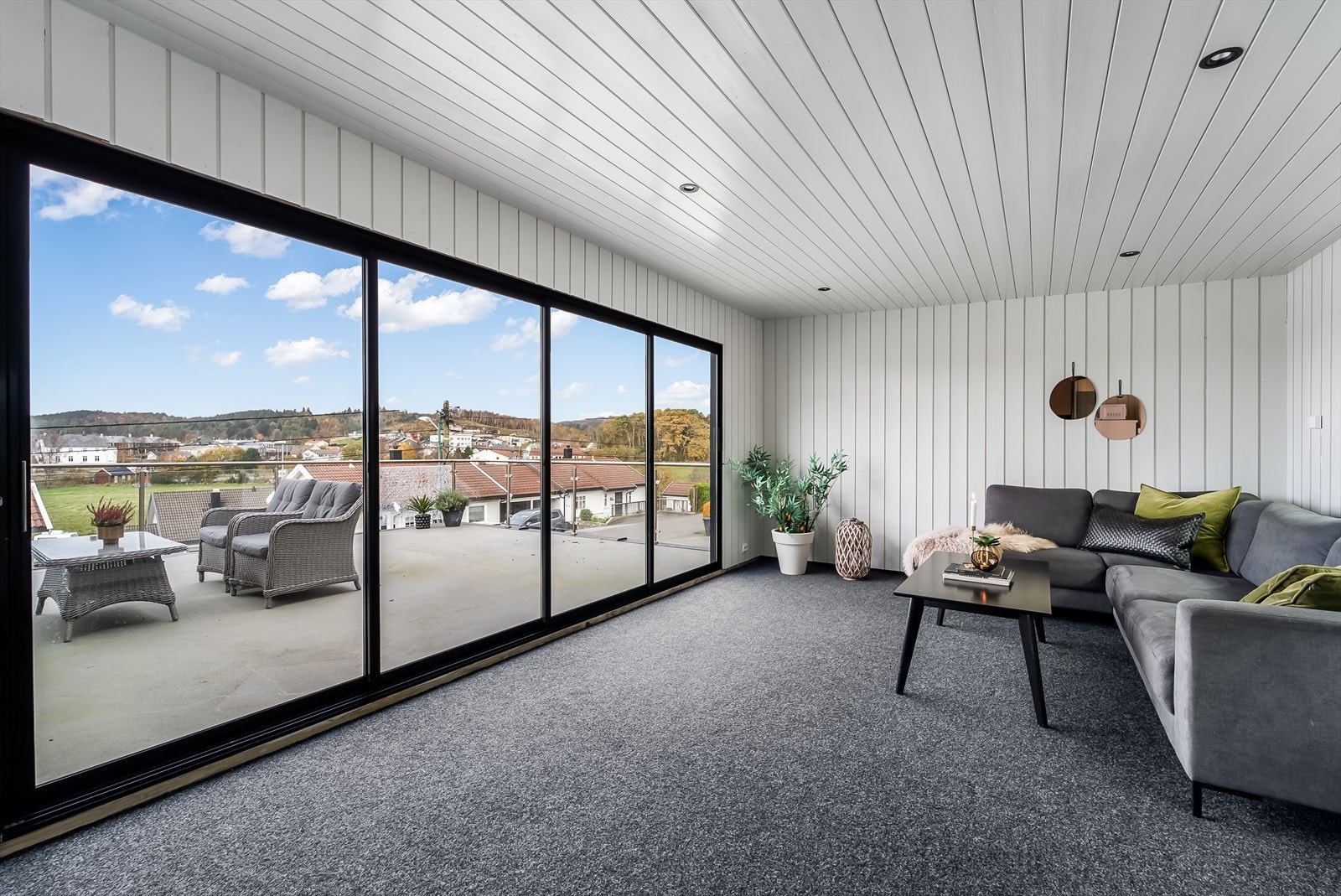 Hagestue med skyvedører ut mot en solrik terrasse på sommerstid. Galleribilde