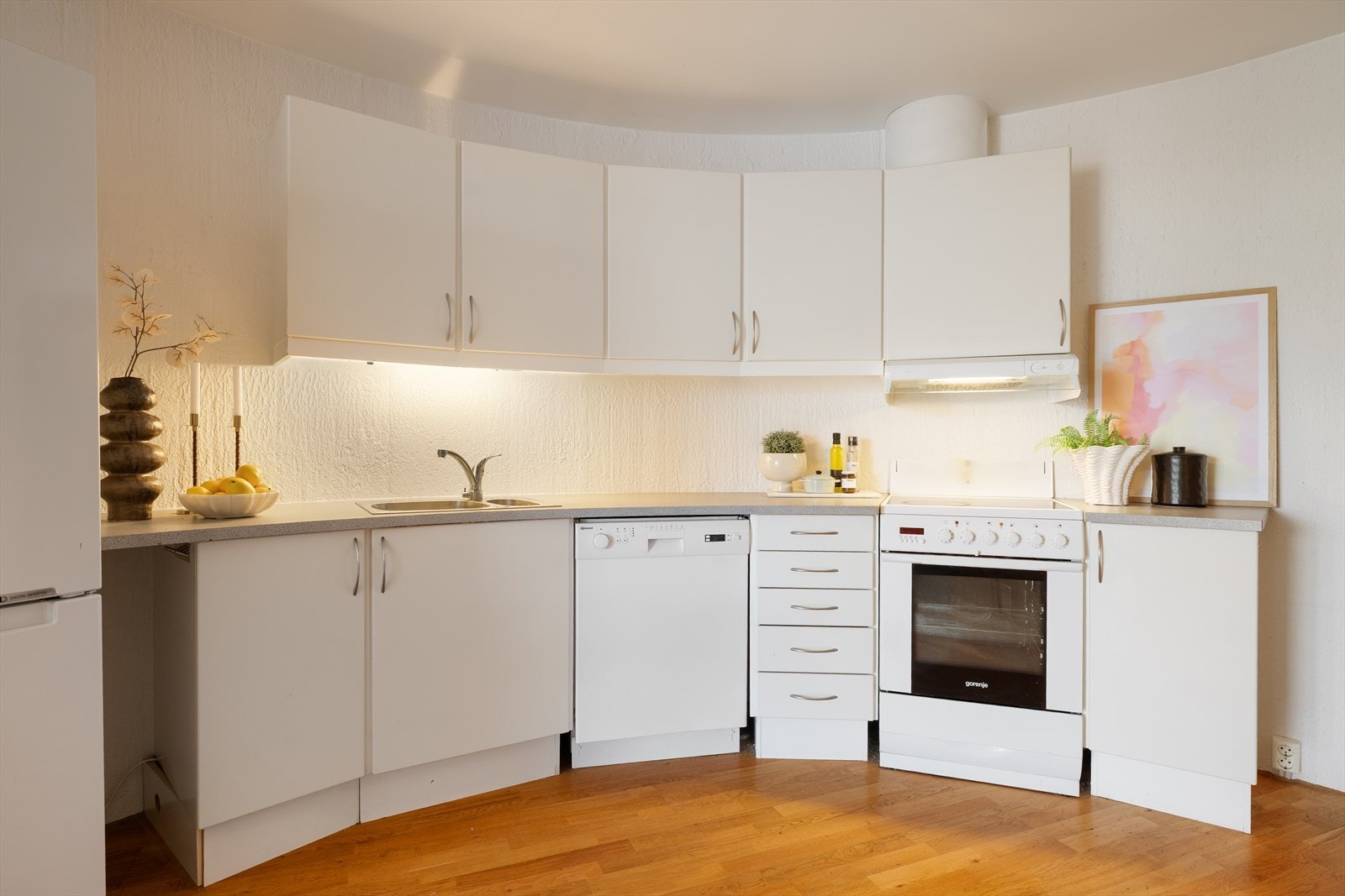 Kjøkkeninnredningen fra 2003 og består av glatte fronter og en halvbuet løsning som følger rommets form. Laminert benkeplate med nedfelt kum i rustfritt stål, belysning under overskap, ventilator og opplegg for oppvaskmaskin. Avtrekk skjer via ventilator. Galleribilde