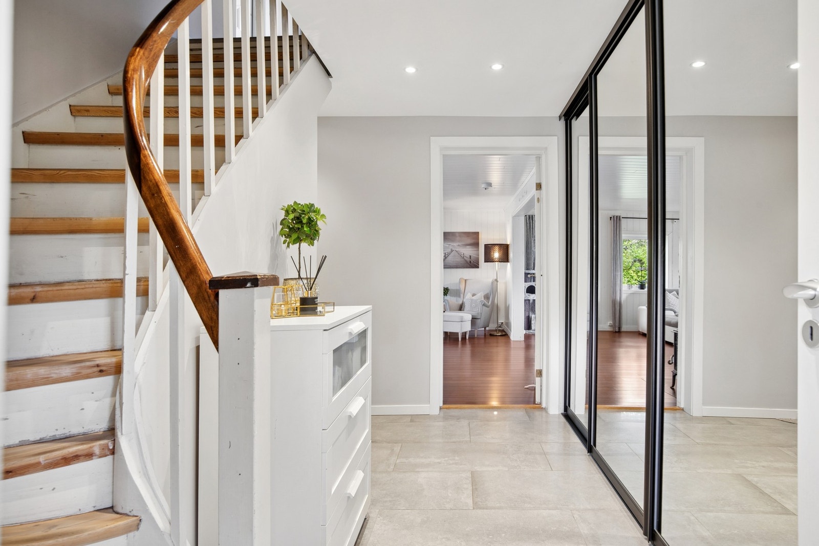 Romslig gang med flislagt gulv, god oppbevaringsplass i skyvedørsgarderobe og trapp opp til boligens andre etasje Galleribilde