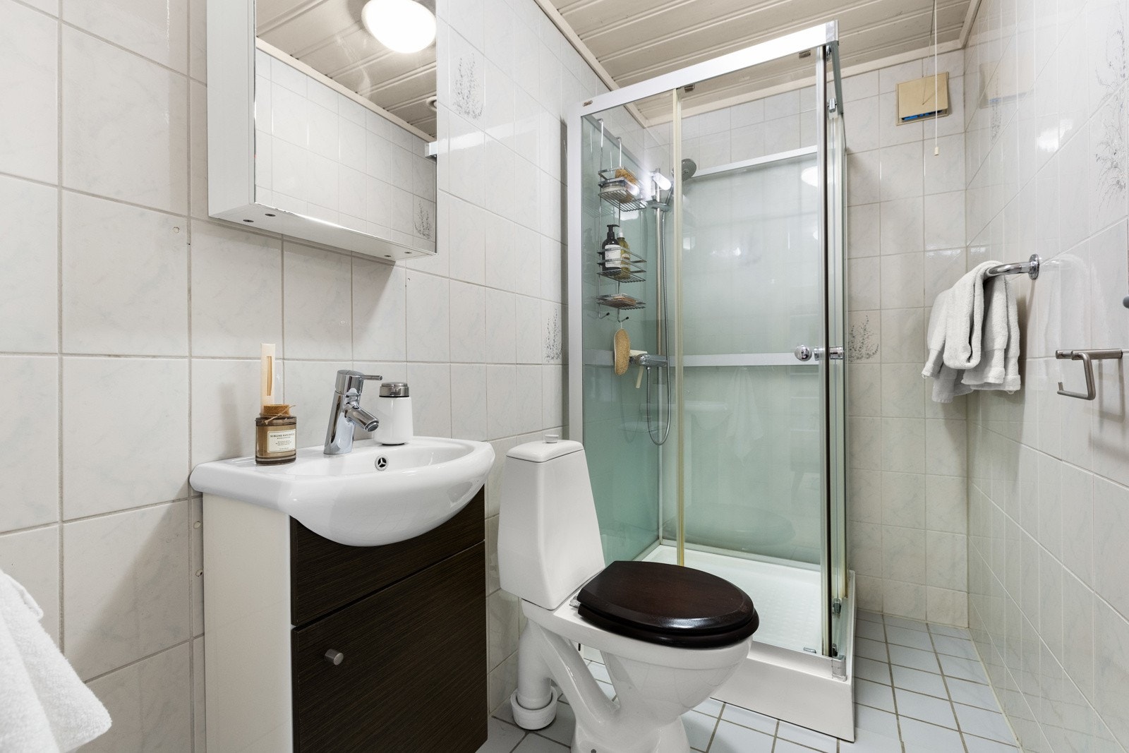 Bad 2. Flislagt bad fra byggår med varmekabler i gulv. Gulvmontert toalett, dusjkabinett og servantskap med servant. Badet har mekanisk avtrekk. Galleribilde