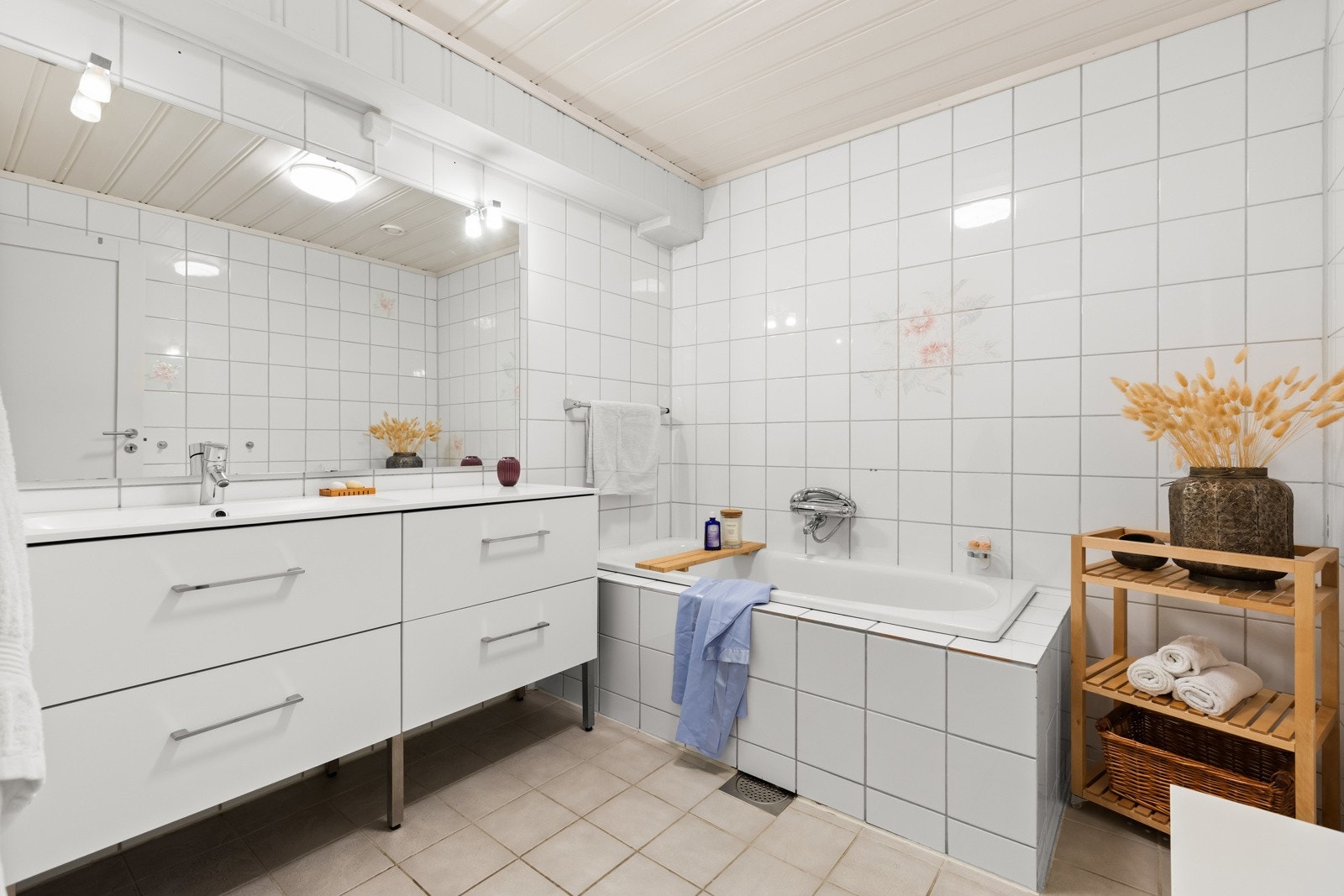 Et romslig hovedbad (fra byggeår) med flislagte flater og varmekabler i gulv. Hel servant med servantskap. Badekar innmurt/fliset med termostat blandebatteri. Baderomsinnredning med skuffer. Det er opplegg for bide på veggen. Galleribilde