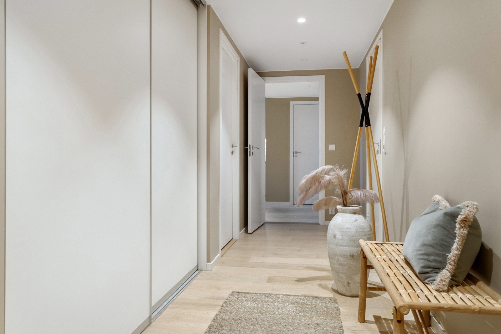 Man kommer inn i en stor og lys entrè med skyvedørsgarderobe. Galleribilde