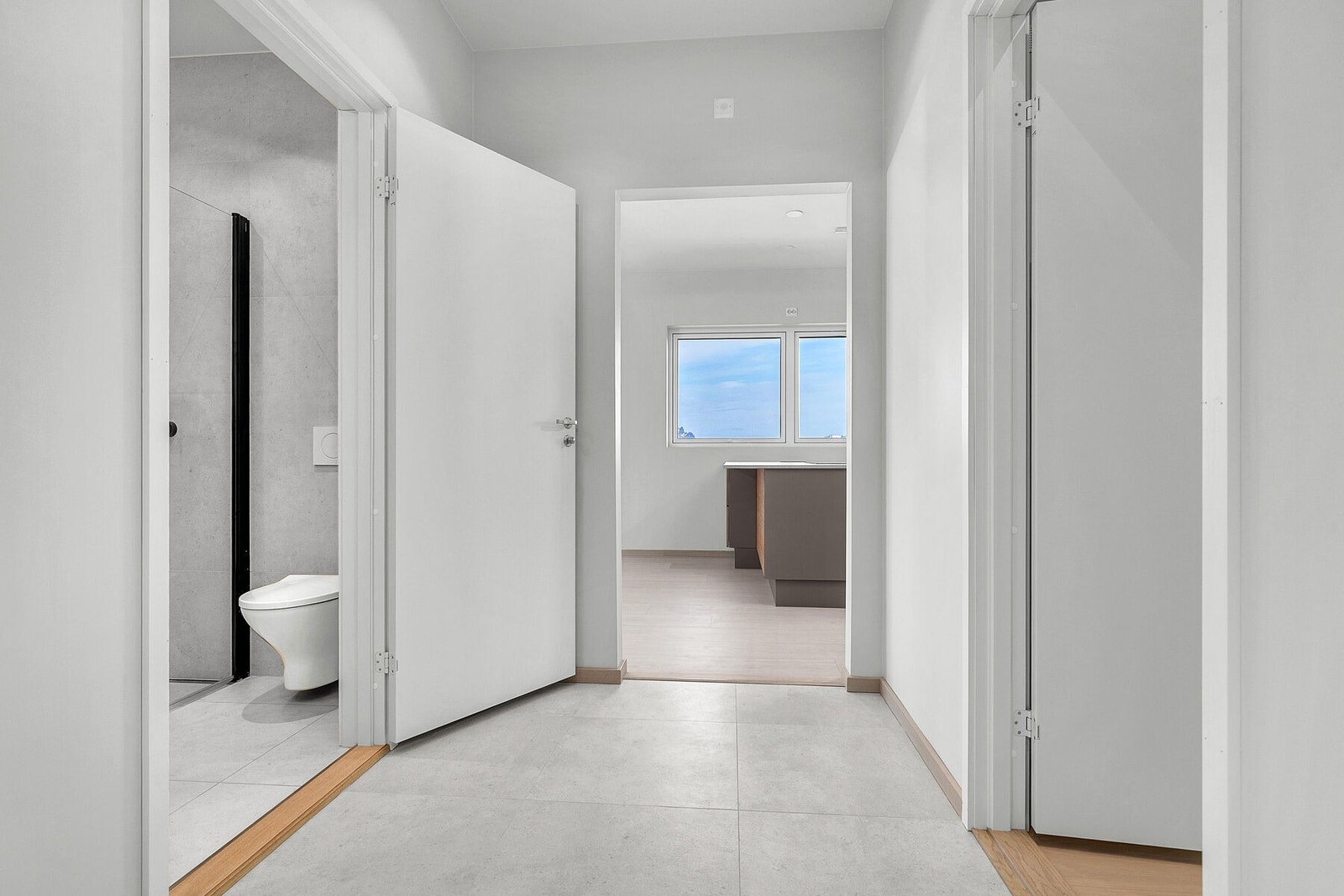 Gang med fliser på gulv, varmekabler og spotter i tak. Galleribilde