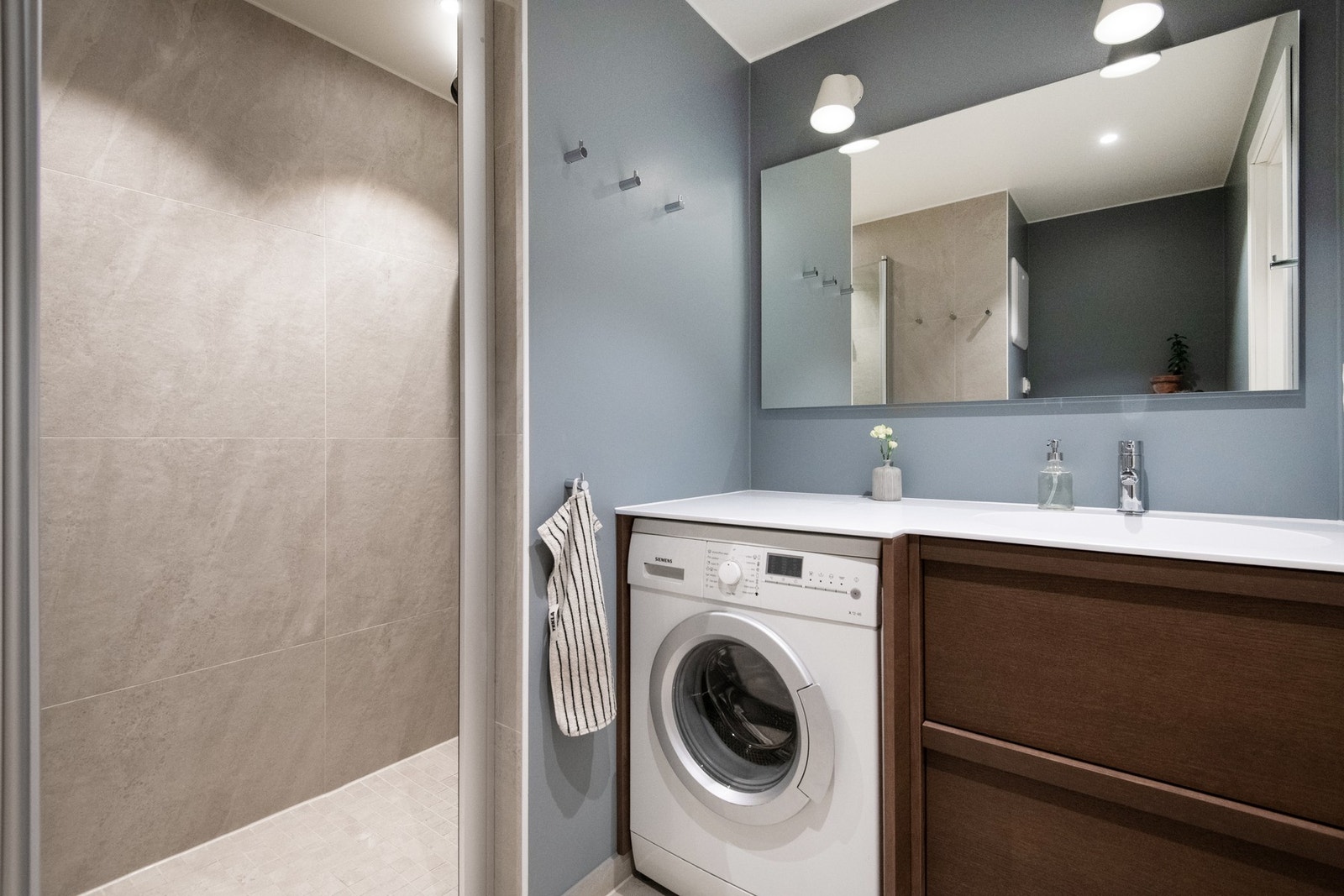 Gulvet er flislagt og har varme for ekstra komfort, mens de flislagte veggene i dusjsone gir et tidløst uttrykk. Galleribilde