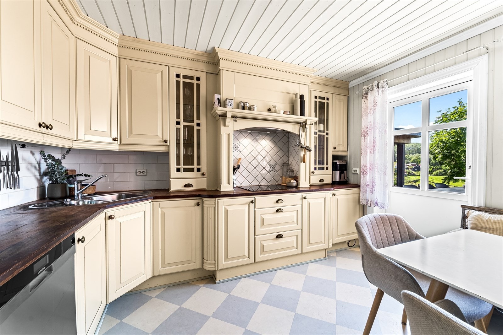 Lyst og innbydende kjøkken med klassiske detaljer, god arbeidsplass og et naturlig samlingspunkt. Utgang til terrassen i front. Galleribilde