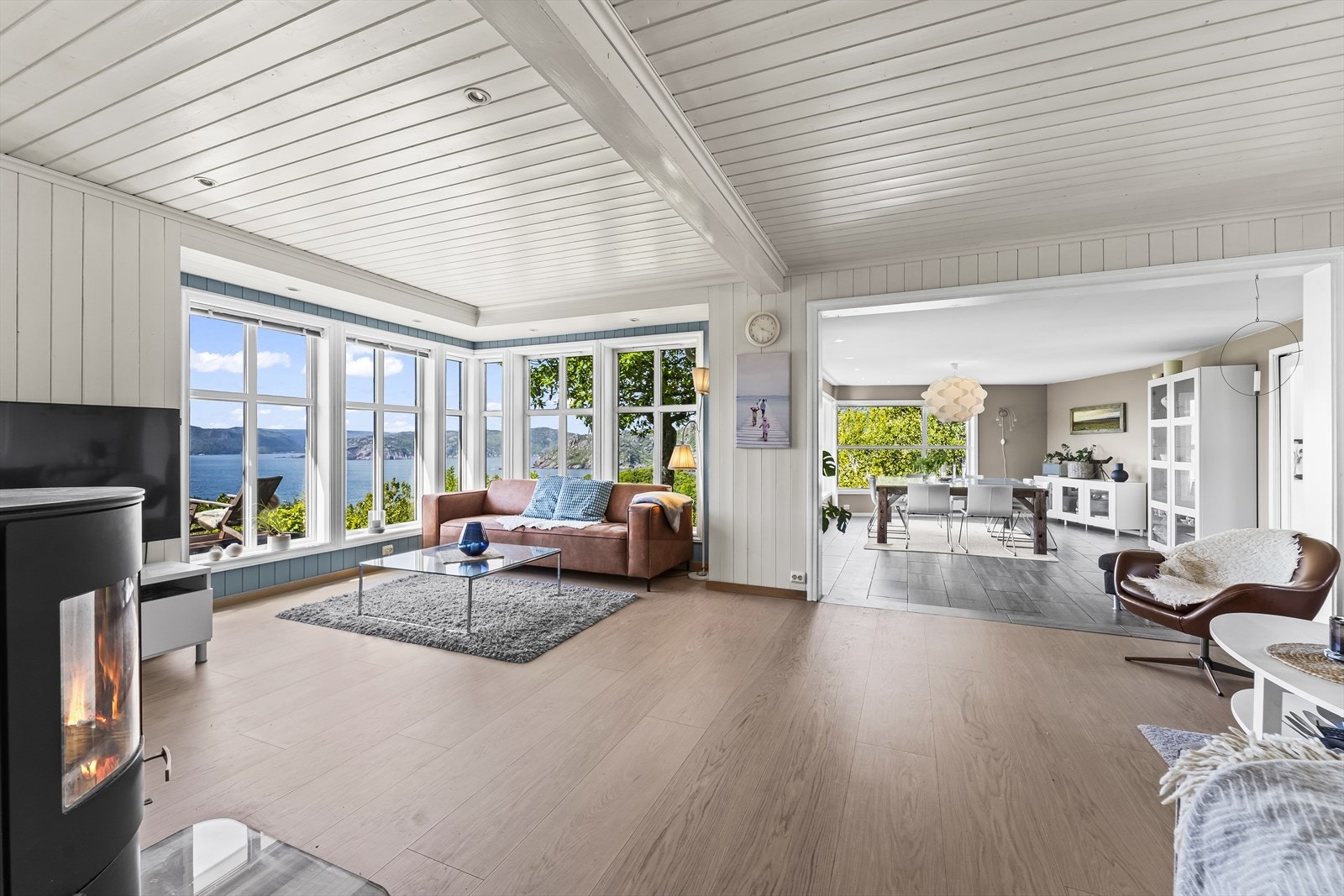 Lys og romslig stue med panoramautsikt over fjorden, store vinduer slipper inn rikelig med naturlig lys. Galleribilde