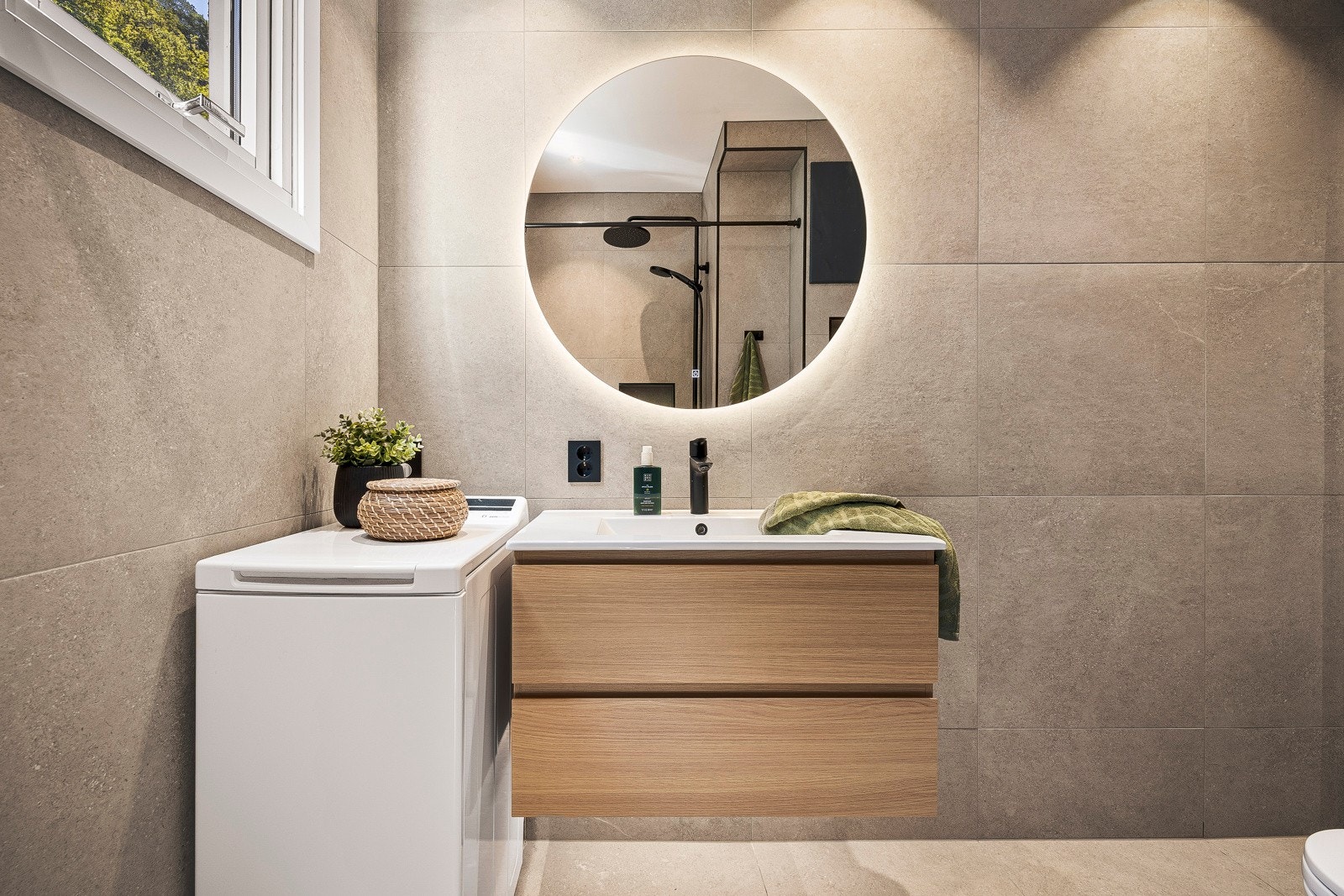 Badet er innredet med vegghengt toalett, dusjhjørne m/forheng, veggskap og servant med innredning, samt belyst speil. Galleribilde