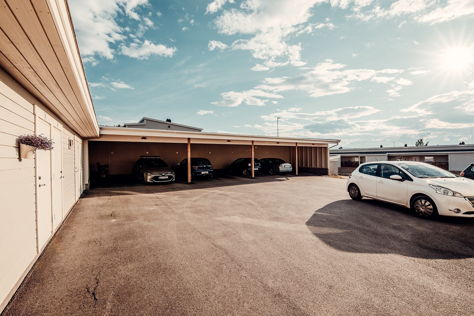 Hver leilighet disponerer utebod i rekke på bakkeplan ved inngangspartiet, og biloppstillingsplass i felles carportanlegg. Galleribilde